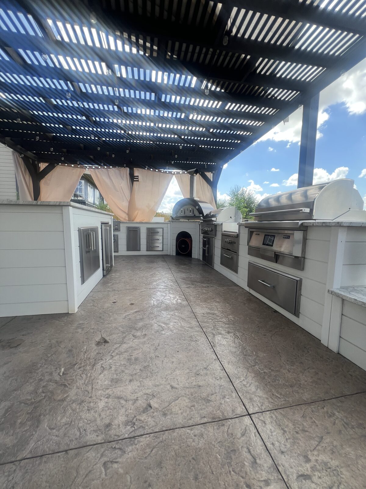 Outdoor kitchen wide angle, pergola and string lights