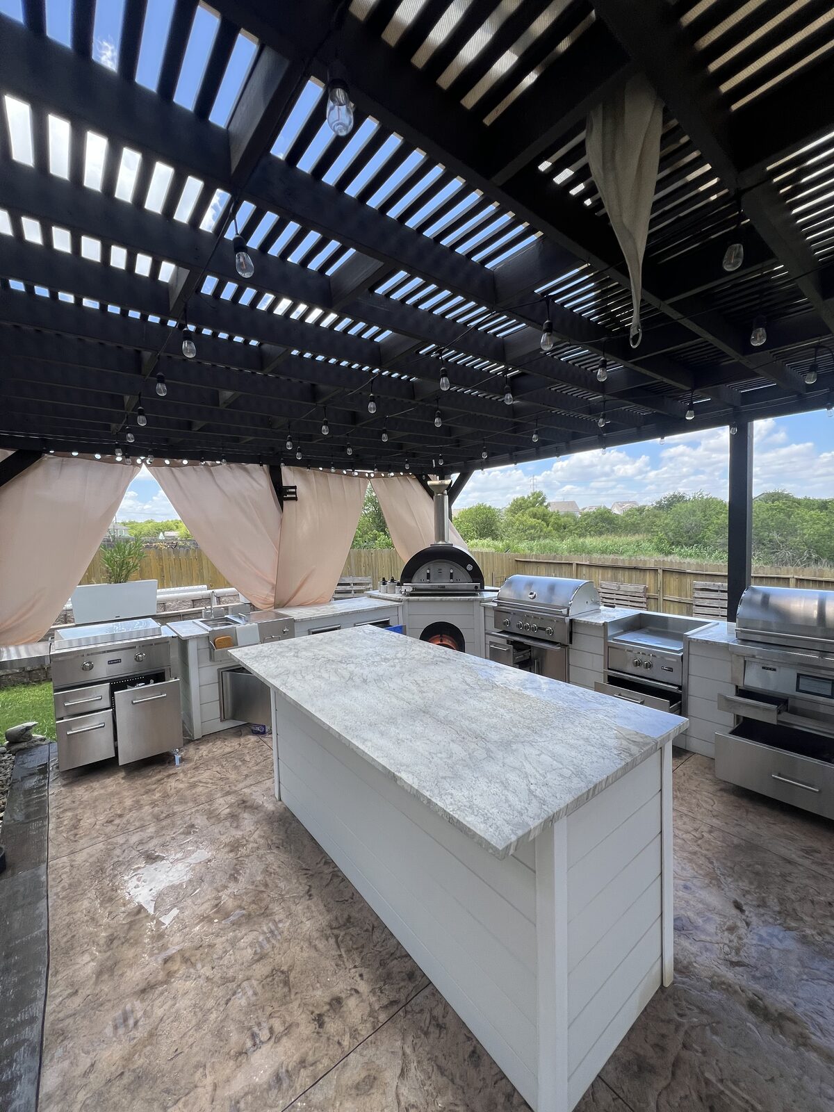 Outdoor kitchen entry view with sink and grill station