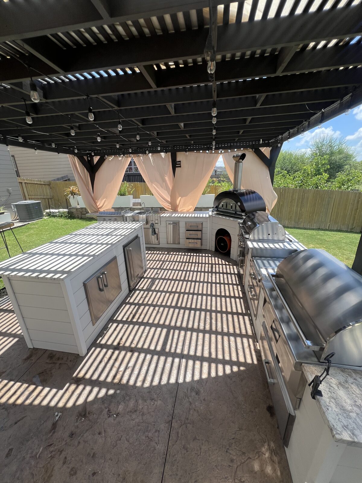 Wide view of outdoor kitchen island and appliances