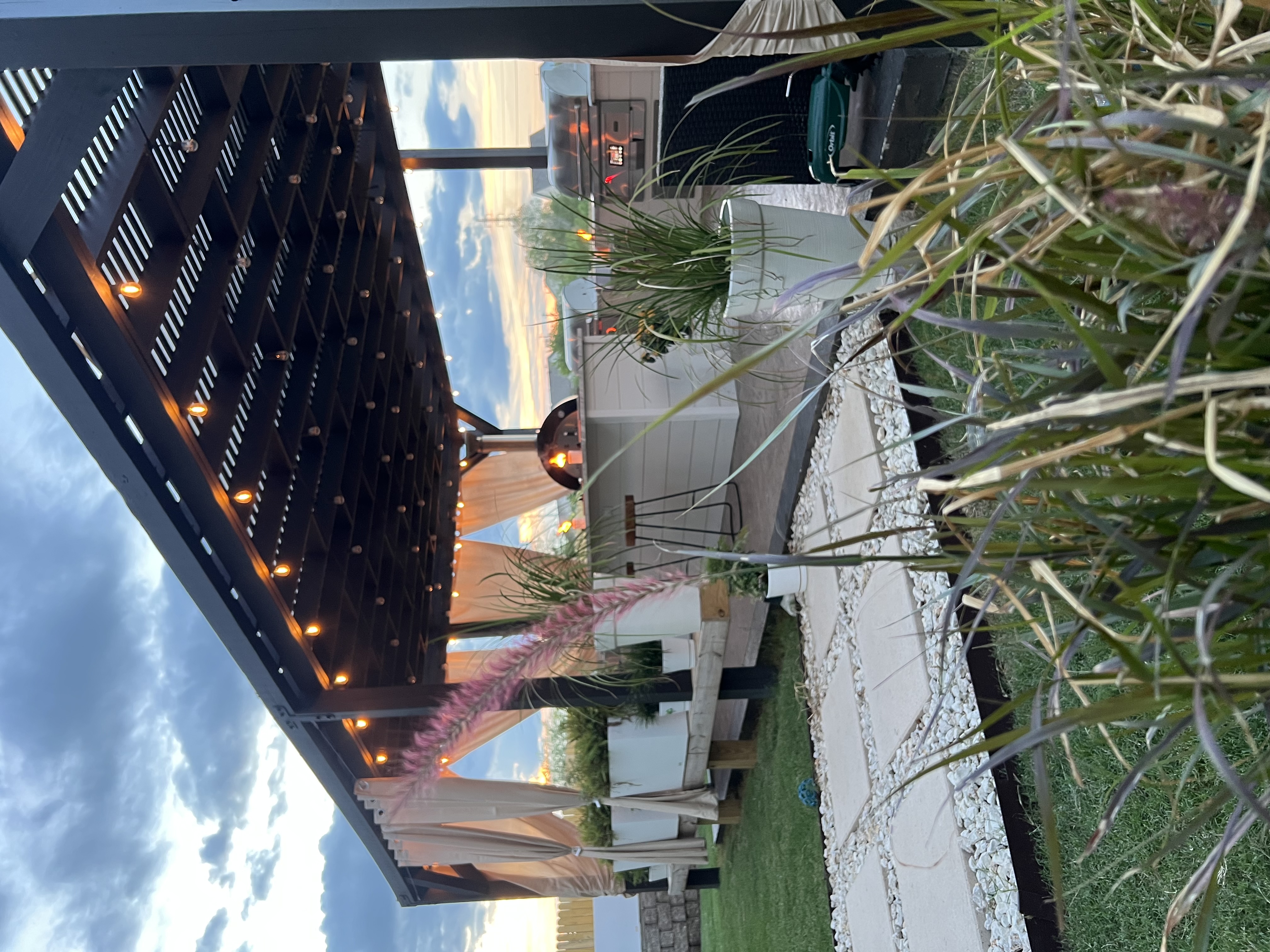 Outdoor kitchen with lit pizza oven at dusk, San Antonio